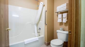 A bathroom with a bathtub, toilet, and a towel rack.