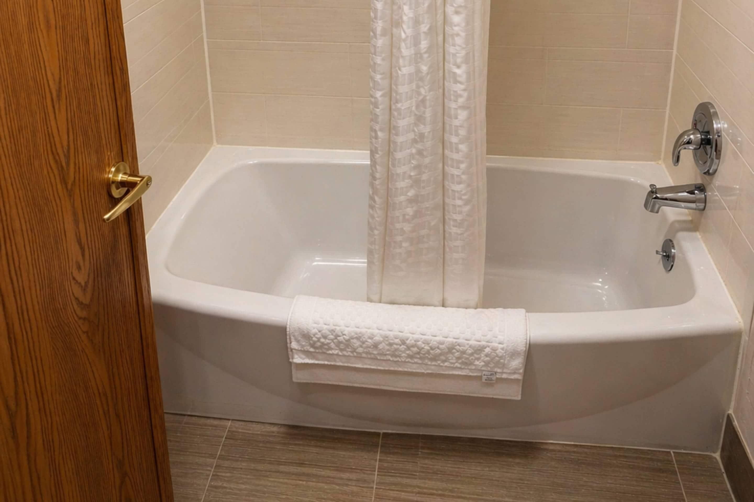 Une salle de bain avec une baignoire, un rideau de douche et une serviette.