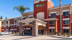 Ein mehrstöckiges Hotel mit einem gut sichtbaren 'Extended Stay America'-Schild, einem Eingangsbereich und einem Parkplatz.