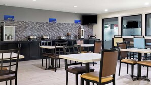 Un restaurant moderne doté d’un bar, de nombreuses tables et chaises, et d’une cuisine située à l’arrière.