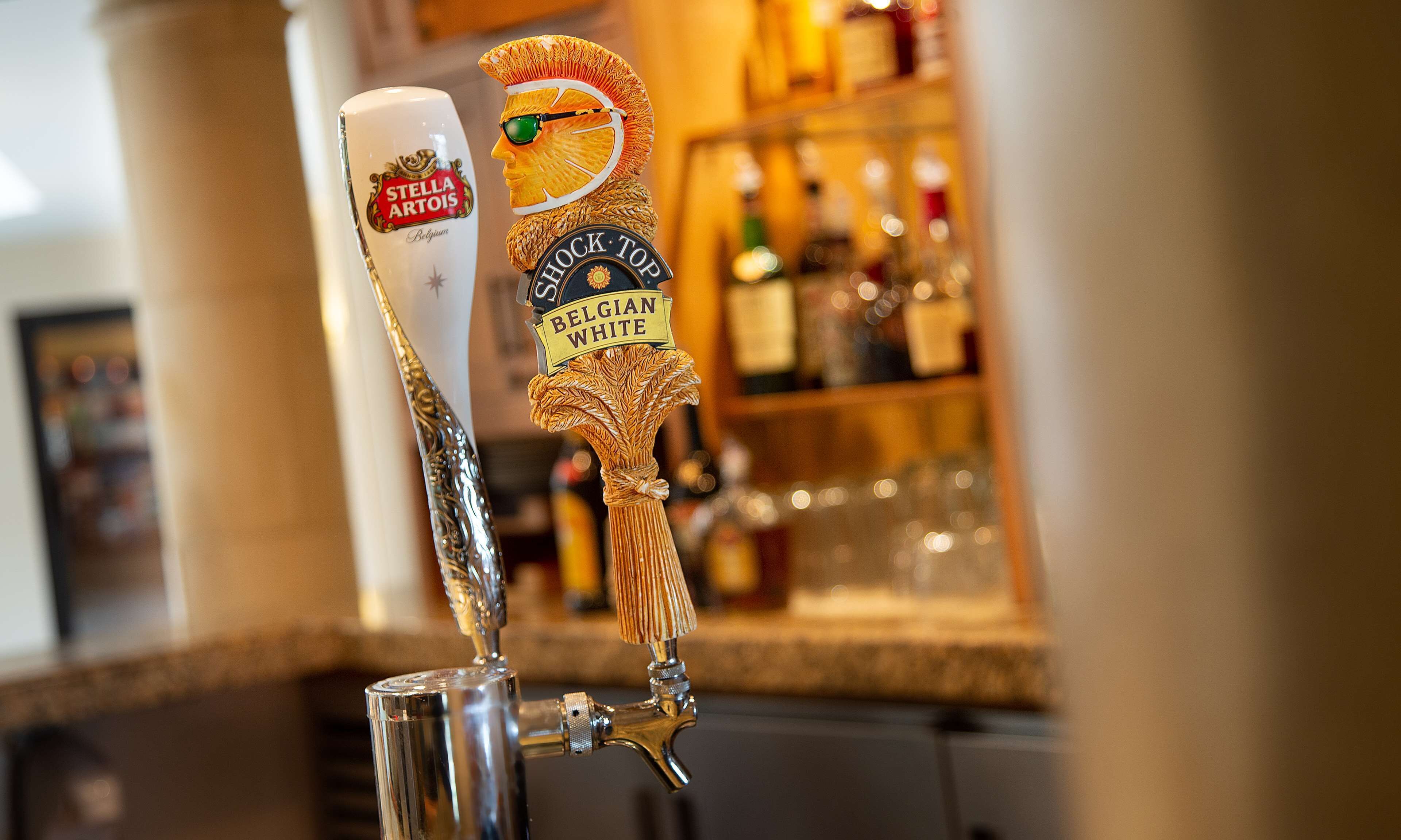 A tap with two beer taps, one labeled "Stella Artois" and the other "Rock Top Belgian White".