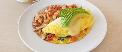 Un plato con tortilla, aguacate y verduras.