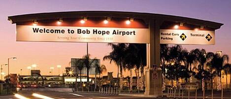 A welcome sign at Bob Hope Airport with directions to rental cars and the terminal.