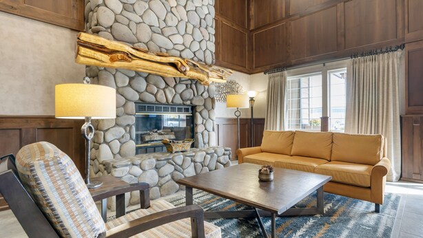 Ein gemütliches Wohnzimmer mit Kamin aus Stein, einer Couch und einem Couchtisch.