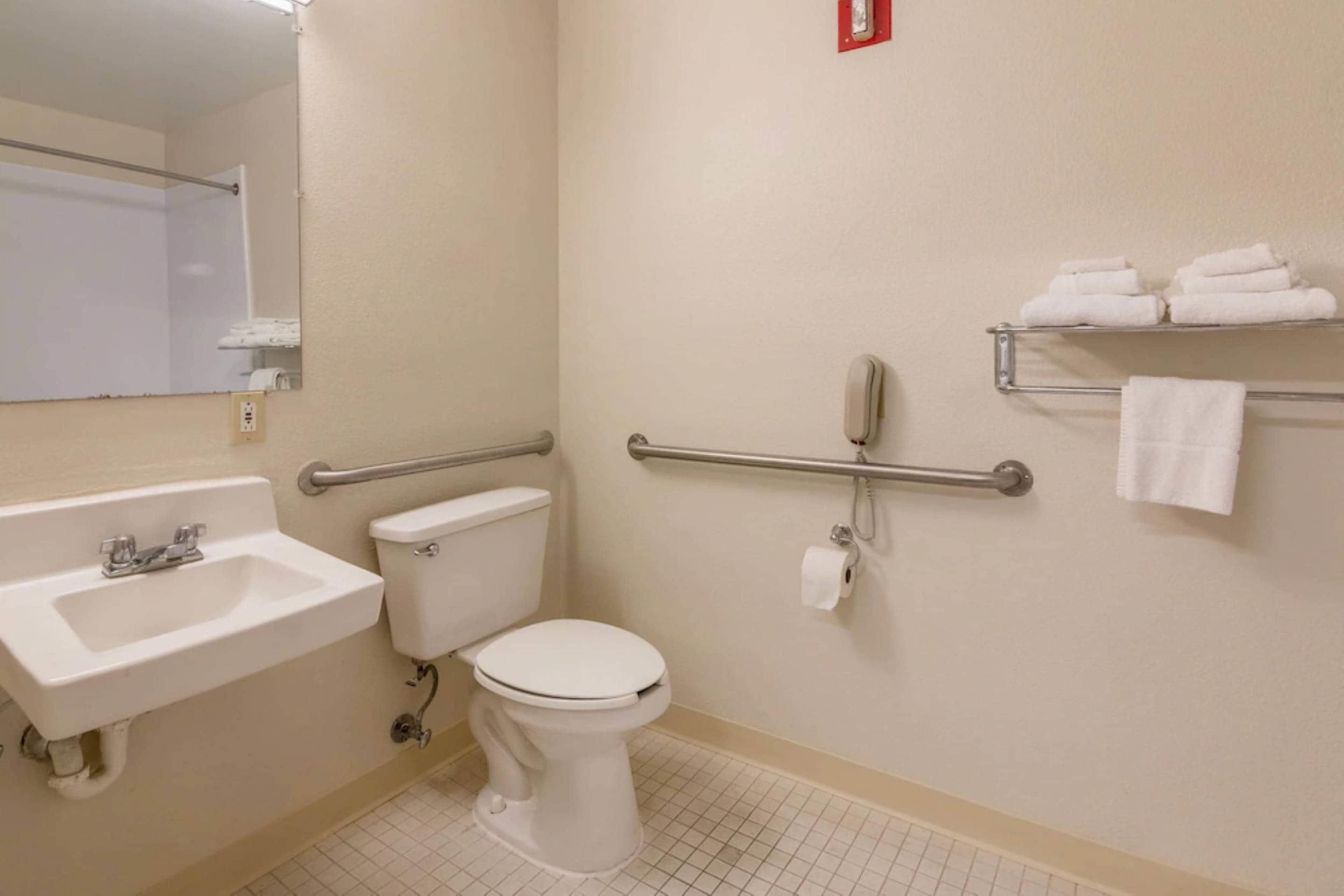 A bathroom with a sink, toilet, and towel rack.