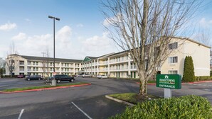 Un motel de varios pisos con un letrero verde que indica la entrada.