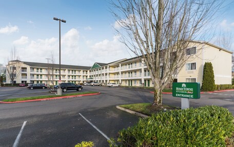 A multi-story motel with a green sign indicating the entrance.