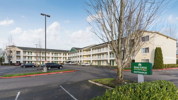 Un motel de varios pisos con un letrero verde que indica la entrada.
