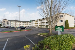 A multi-story motel with a green sign indicating the entrance.
