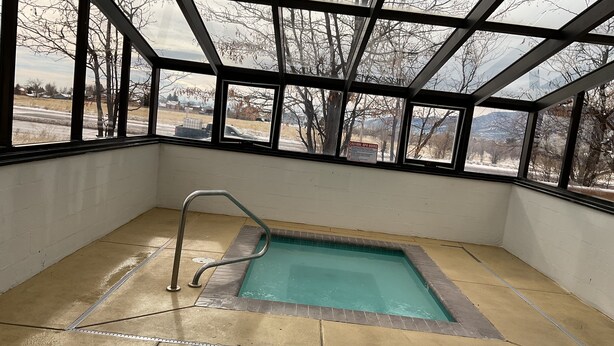 A spa area with a pool, large windows, and a view of the surrounding landscape. - Days Inn by Wyndham Colorado Springs Airport (Colorado Springs)