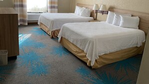 A hotel room with two beds, a desk, and a window with curtains. - Days Inn by Wyndham Colorado Springs Airport (Colorado Springs)