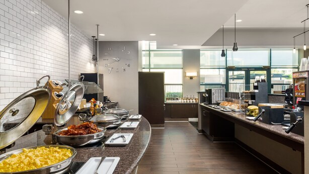 A buffet setup with various food items and utensils.