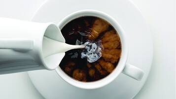 Uma chávena de café branco com uma colher.