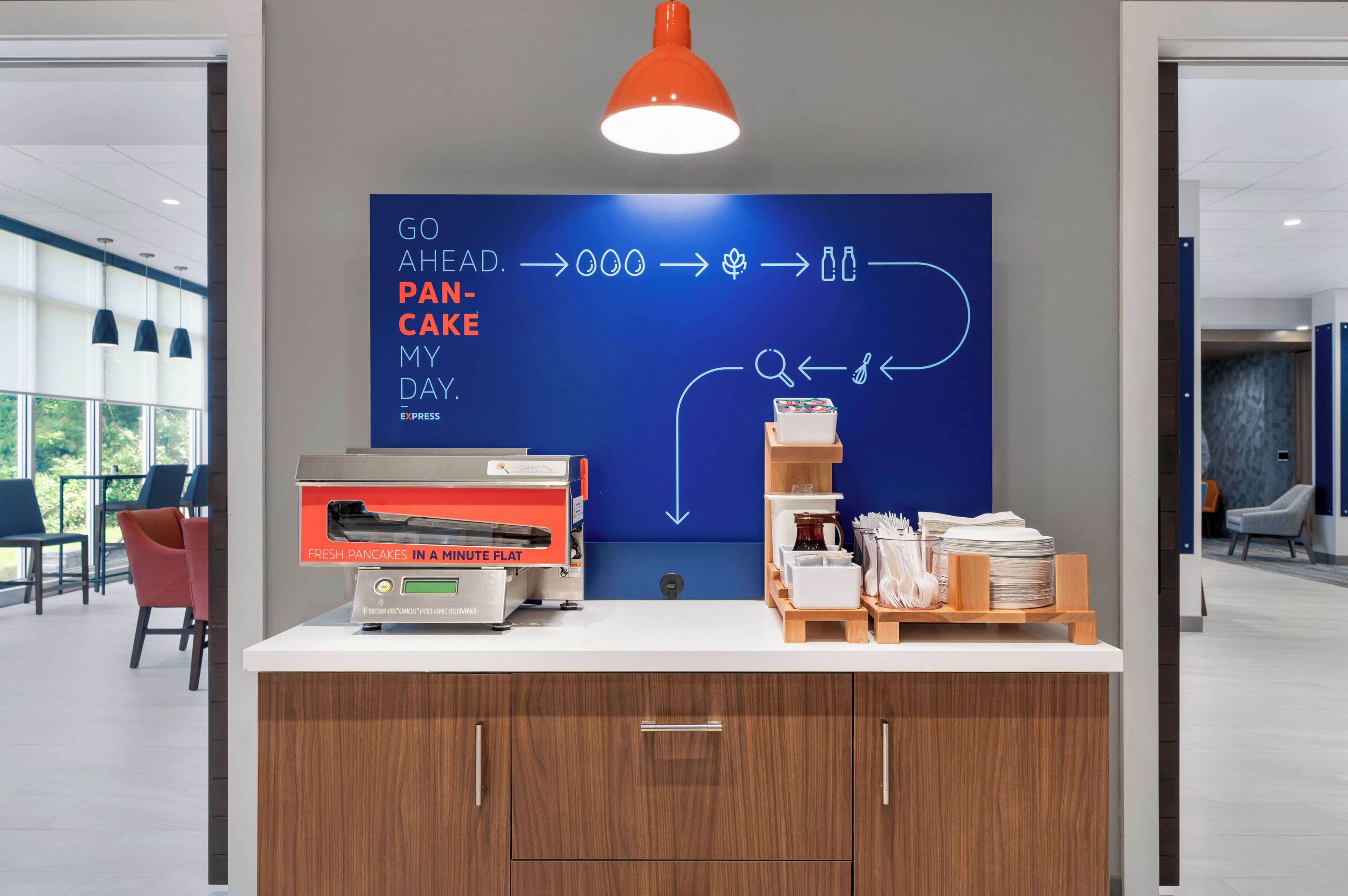 A breakfast station with a sign indicating fresh pancakes are made in a minute flat.