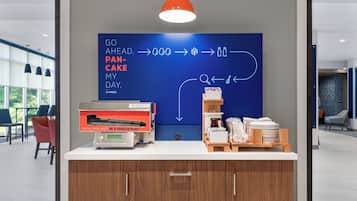 A breakfast station with a sign indicating fresh pancakes are made in a minute flat.