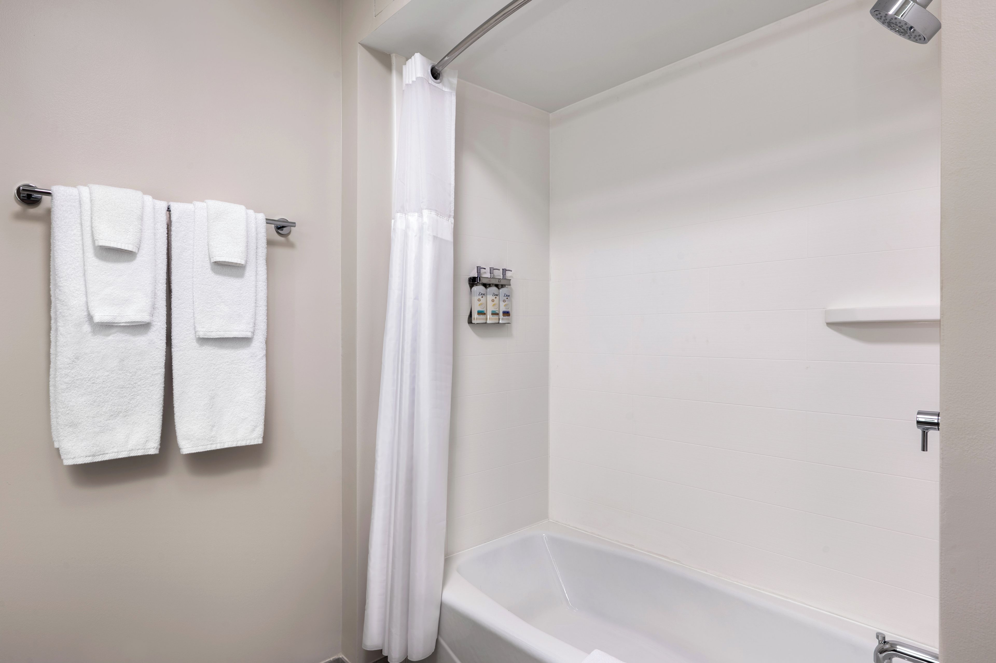 A bathroom with a bathtub, a shower curtain, and two towels hanging on a towel rack.