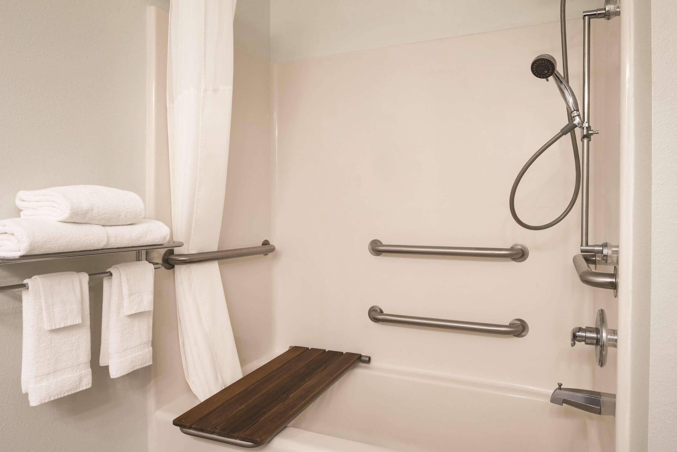 Une salle de bain équipée d’une baignoire, d’une douche et d’un porte-serviettes avec des serviettes pliées.