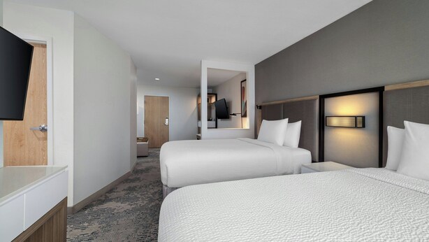 A hotel room with two beds, a TV, a desk, and a bathroom. - SpringHill Suites Dallas Arlington North (Arlington)
