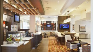 A hotel lobby with a reception desk, seating area, and a bar. - Courtyard by Marriott Pueblo Downtown (Pueblo)