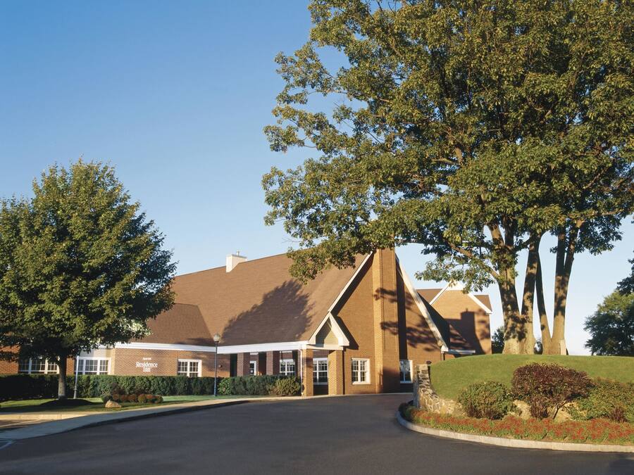 A brick building with a pitched roof and a covered entrance.