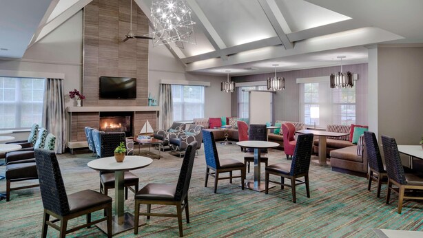 A spacious lounge area with multiple seating options, a fireplace, and a large flat-screen TV. - Residence Inn by Marriott Portsmouth (Portsmouth)