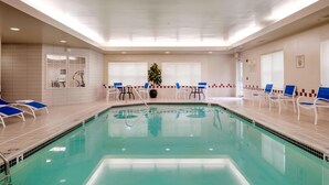 A swimming pool with lounge chairs and a small table in the center. - Residence Inn by Marriott Portsmouth (Portsmouth)