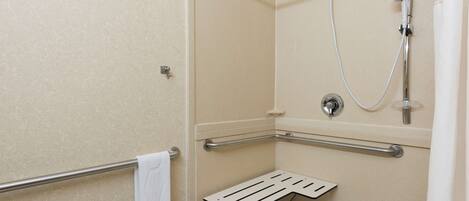 Un espace douche équipé d’une barre d’appui, d’un porte-serviettes et d’un pommeau de douche.