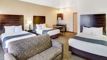 A hotel room with two beds, a sofa, a desk, and a microwave.