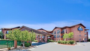 A Days Inn & Suites building with a brick facade, multiple balconies, and a clear blue sky. - Days Inn & Suites by Wyndham Page Lake Powell (Page)