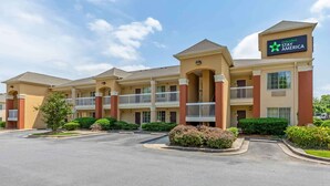 A hotel with multiple balconies, a parking lot, and well-maintained landscaping. - Extended Stay America Select Suites Baltimore BWI Airport (Linthicum Heights)
