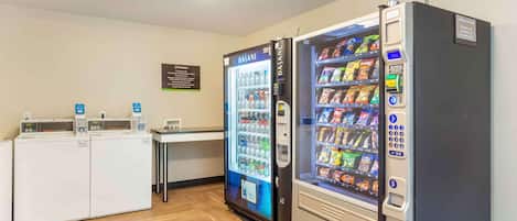 A hotel room with a minibar, a refrigerator, and a vending machine.