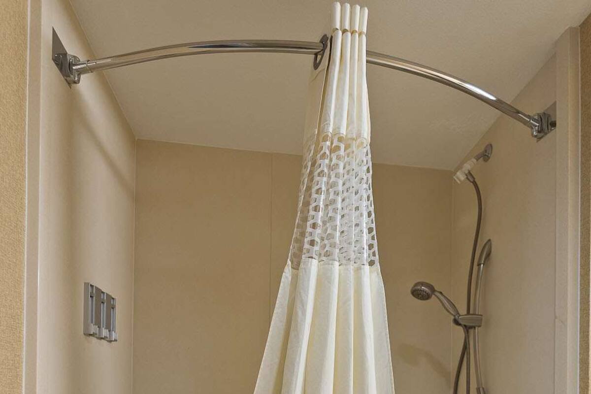 A bathroom with a bathtub, a shower, and a curtain.