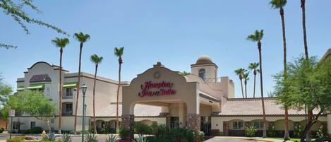 A hotel with a prominent sign reading "Hampton Inn & Suites."