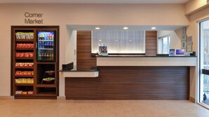 A reception area with a 'Corner Market' sign, vending machines, and a counter.