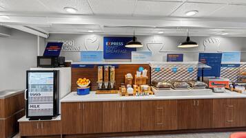 Un área de desayuno con un menú digital, diferentes opciones de comida y un letrero que dice 'EXPRESS BREAKFAST'.