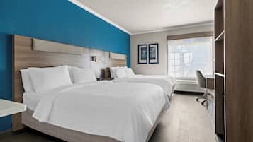 Habitación de hotel moderna con una cama grande, un escritorio y vistas al exterior.