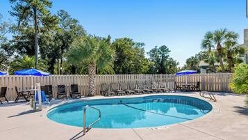 Una piscina al aire libre, tumbonas