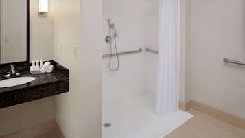 Une salle de bain moderne avec un lavabo, un miroir et une douche.
