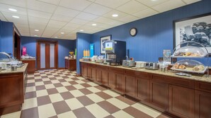 A breakfast bar with a checkered floor, a clock, and a coffee machine.