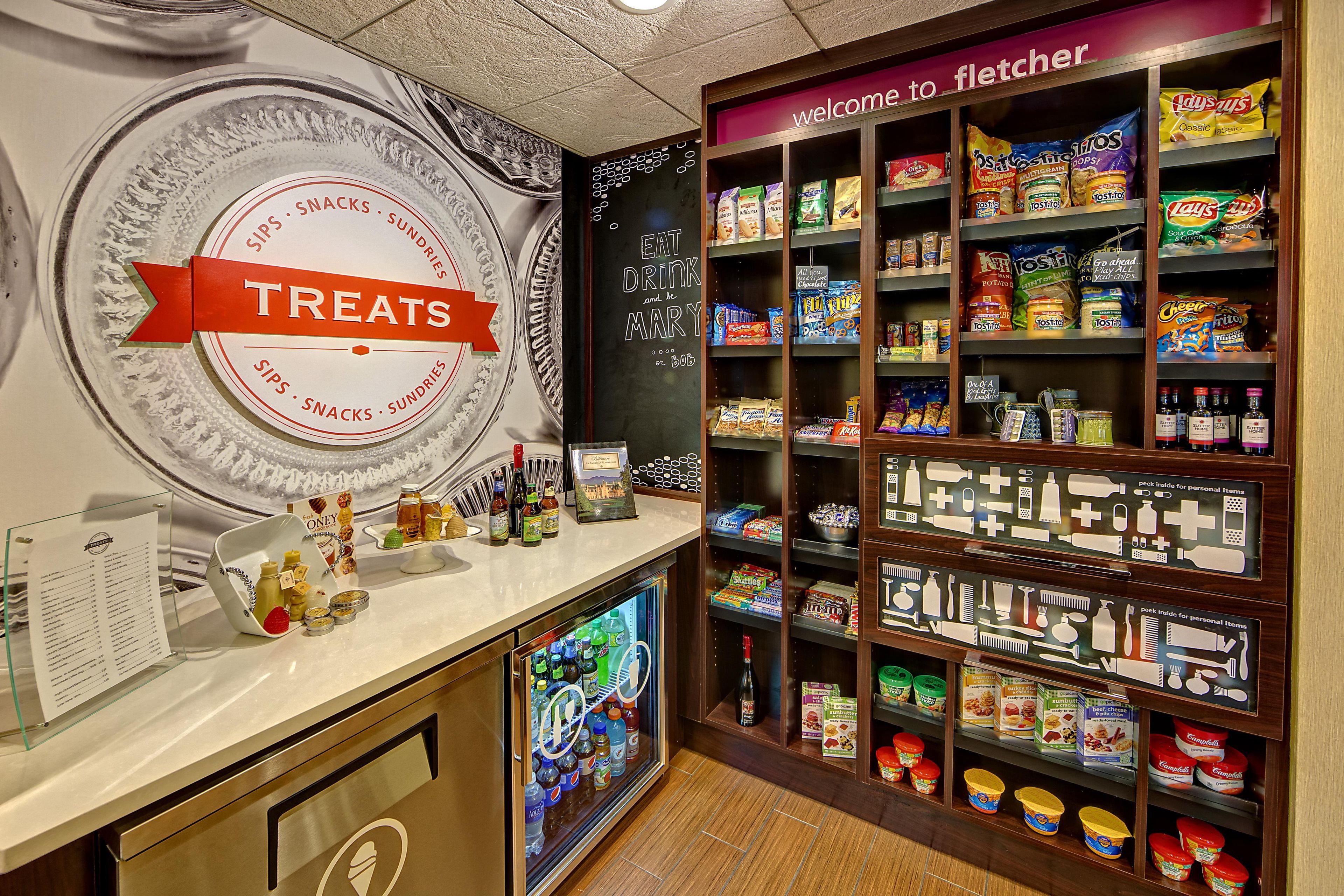 Un espace dédié aux collations et aux produits de confiserie, avec un assortiment de produits emballés et un tableau affichant le menu.