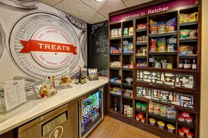 Una sección de aperitivos y dulces con una variedad de productos envasados y un panel de menú.