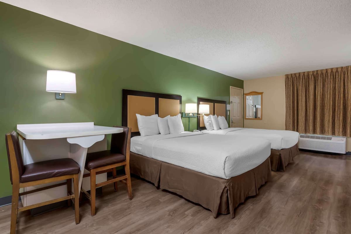 Une chambre d’hôtel avec un lit, un bureau et une chaise.