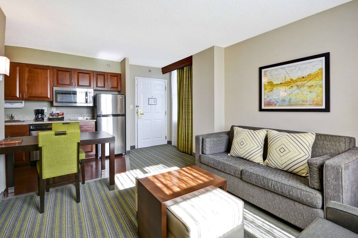 A compact living space with a kitchenette, a sofa, a coffee table, and a dining area.