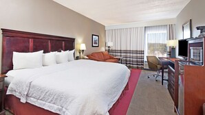 A hotel room with a large bed, a desk, a chair, a TV, and a window with curtains. - Hampton Inn Huntington/Barboursville (Barboursville)