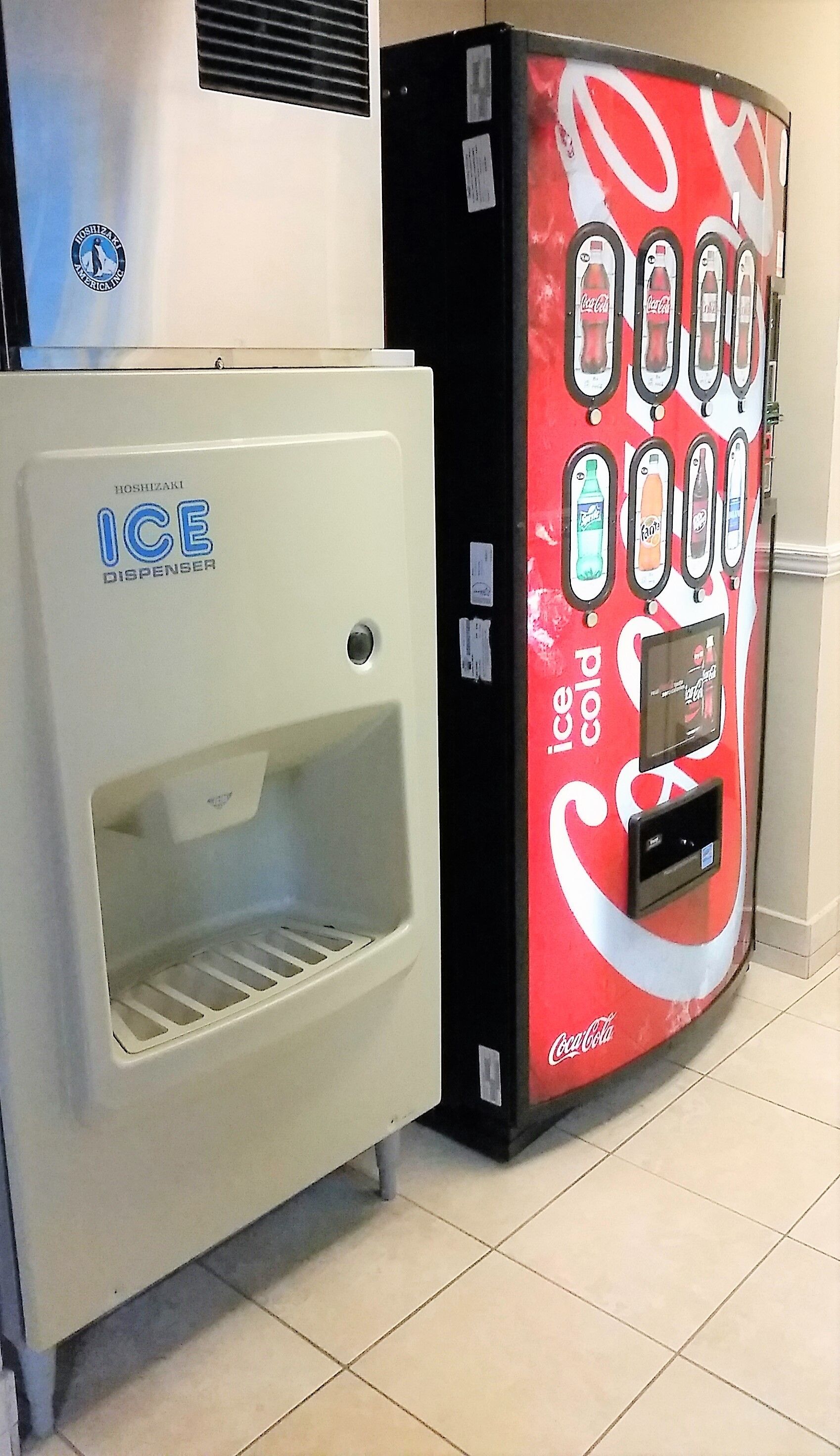 A vending machine with a Coca-Cola logo and an ice dispenser.