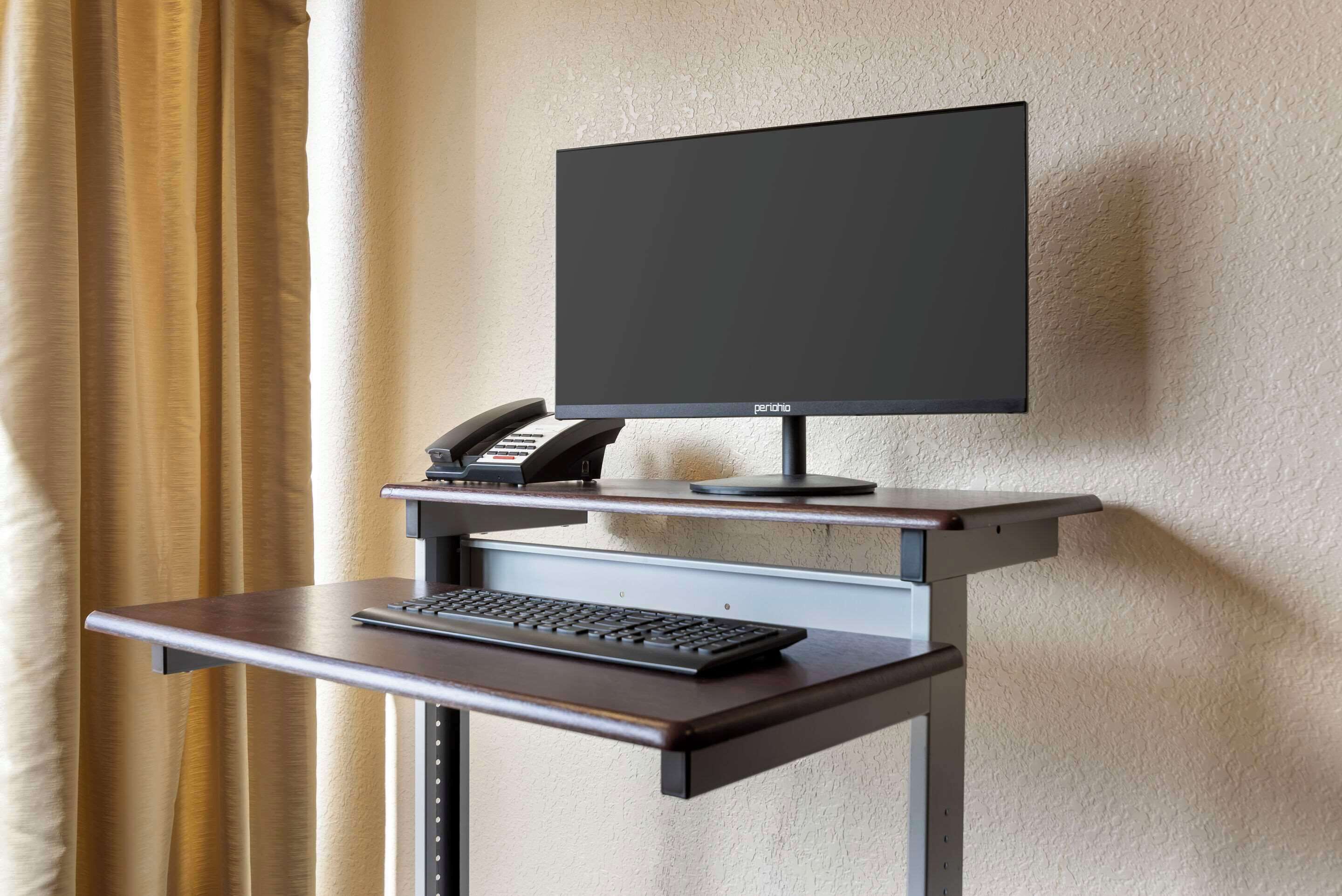 Mostrador de hotel con monitor de pantalla plana, teclado y teléfono.