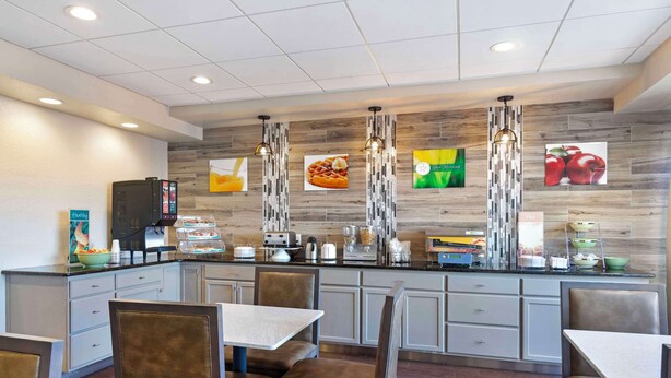 A modern kitchen with a central island, seating area, and various appliances.