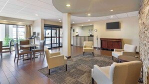 A spacious lobby with a reception desk, seating area, and a stone accent wall.