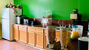 A kitchen with wooden cabinets, a refrigerator, a coffee maker, and a blender. - Holiday Lodge (Greensboro)