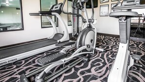 A hotel fitness center with treadmills, elliptical machines, and a stationary bike.